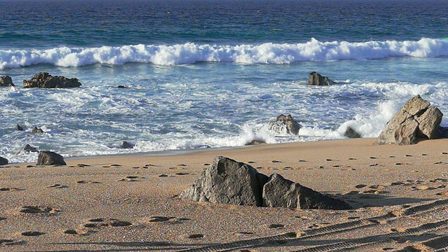 女人在海滩上跑步，海浪在背景，慢动作视频素材