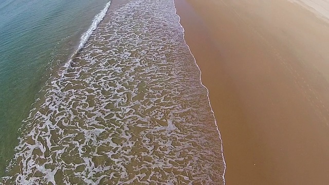 海浪冲击着海滩，鸟瞰图向后移动视频素材