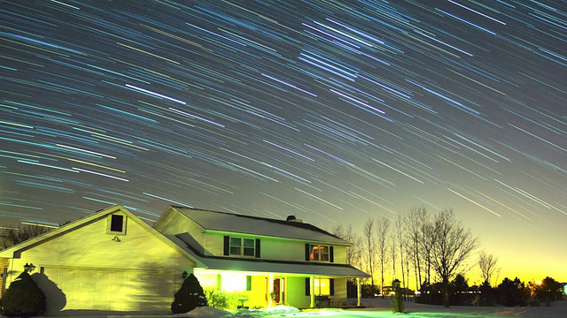 带有轨迹的星星划过房子上方的冬季夜空视频素材