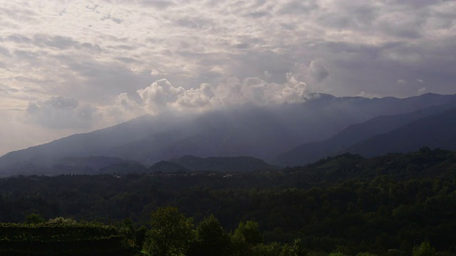 随着时间的流逝，巨大的云层随着神的光芒在山峦、树木和意大利葡萄园上空演变视频素材