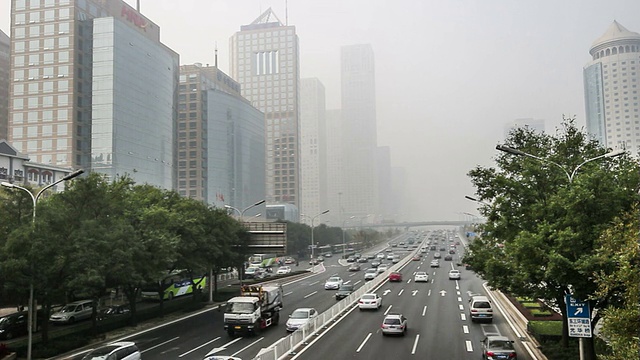 中国北京，2014年10月25日:在恶劣的天气下，中国北京国贸CBD的建筑远处笼罩着雾霭视频素材