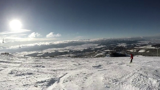 滑雪者从白雪覆盖的森林里的一座小山上下山视频素材