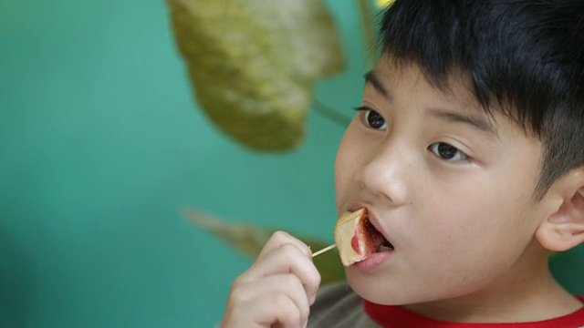 亚洲小男孩在吃零食视频素材