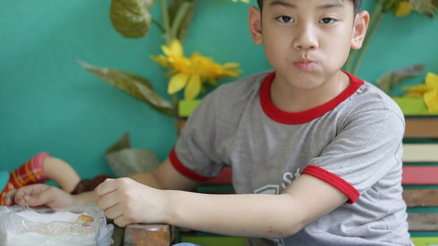 亚洲小男孩在吃零食视频素材