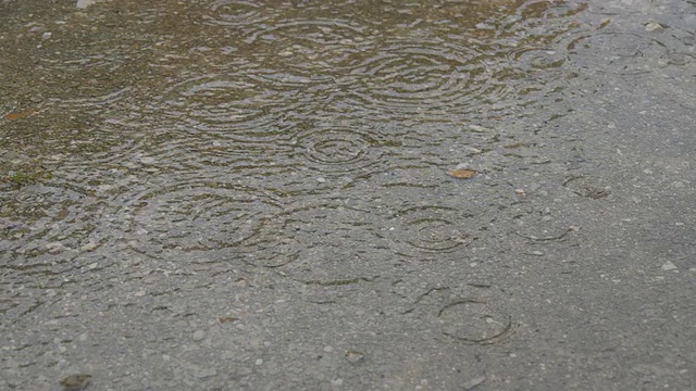 雨点落在水坑上。下雨了。视频素材