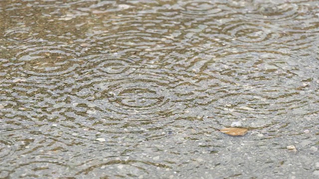 雨点落在水坑上。下雨了。视频素材