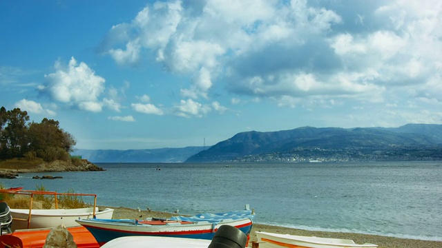 夏日的海景，沙滩上有小船，还有海鸥和云朵视频素材