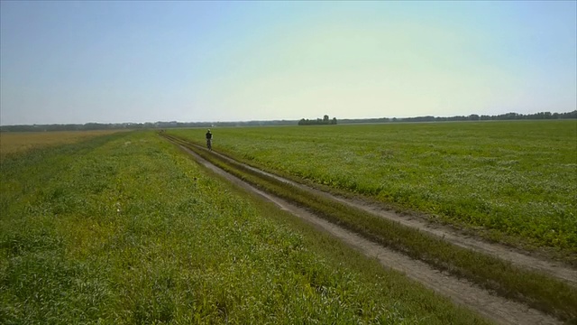 在乡村公路上骑自行车的人。鸟瞰图视频素材