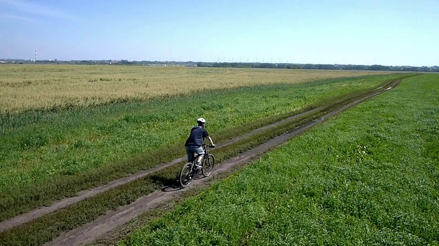 在乡村公路上骑自行车的人。鸟瞰图视频素材