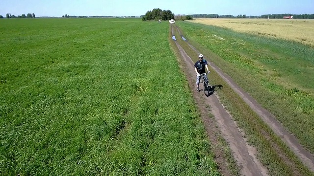 在乡村公路上骑自行车的人。鸟瞰图视频素材