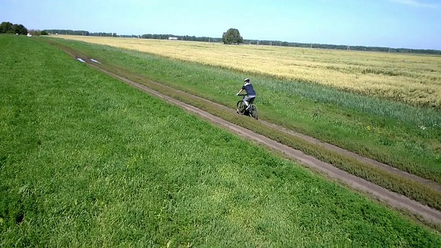 在乡村公路上骑自行车的人。鸟瞰图视频素材