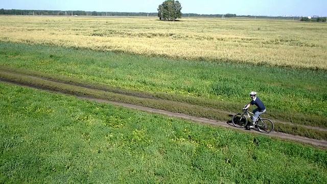 在乡村公路上骑自行车的人。鸟瞰图视频素材