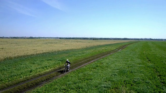 在乡村公路上骑自行车的人。鸟瞰图视频素材