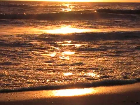 夕阳西下，海浪涌向海滩视频素材