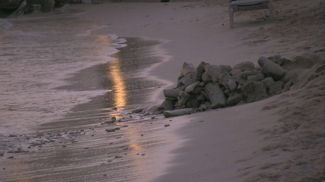 日落时海浪拍打着海滩视频素材