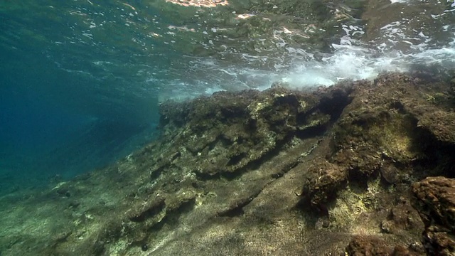 镜头向前移动，海浪拍打着海岸线视频下载