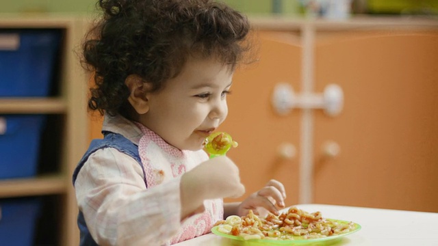 孩子们在幼儿园吃午饭和接吻视频素材