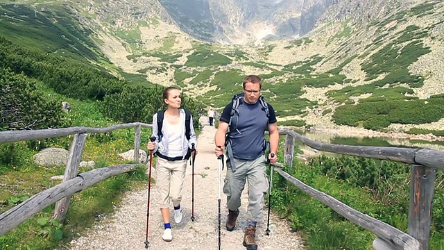 一对情侣在山里徒步旅行，用稳定器拍摄，慢动作视频素材