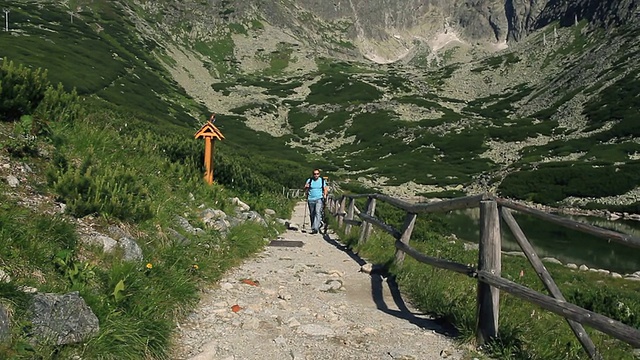 年轻人在山里徒步旅行，用稳定器拍摄视频素材