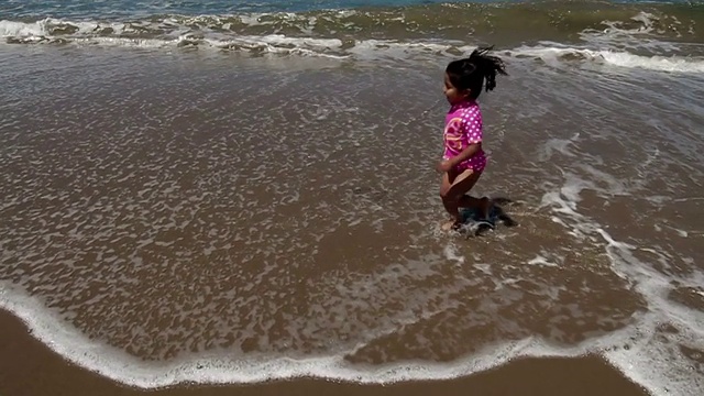 慢镜头中的小女孩在波浪中奔跑视频素材