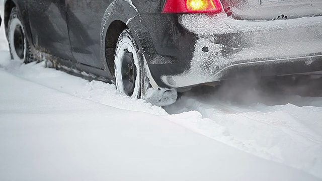 人们帮着把车从雪堆里推出来视频素材