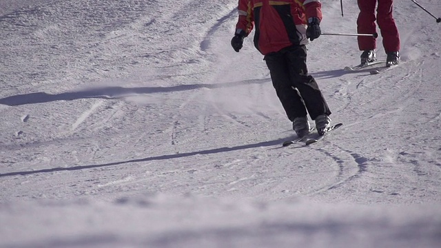 慢镜头:两个滑雪者在斜坡上滑雪视频素材