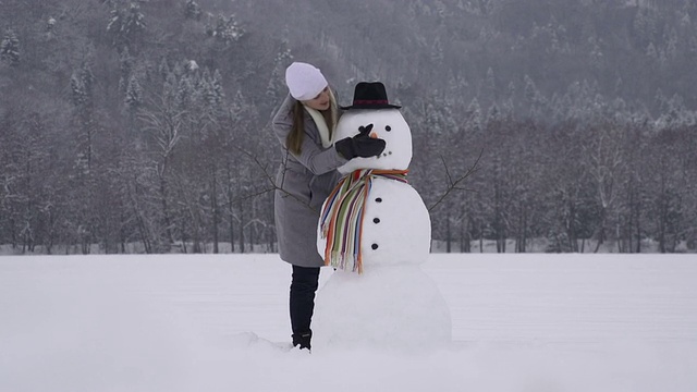 年轻女子正在堆雪人视频素材