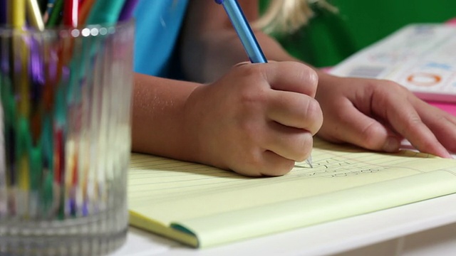 幼儿园学生在便笺簿上写字视频素材