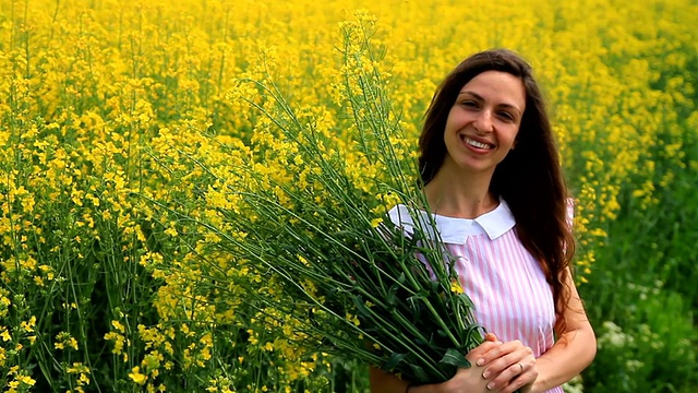 年轻女子放松持有草药鲜花春天田HD视频素材