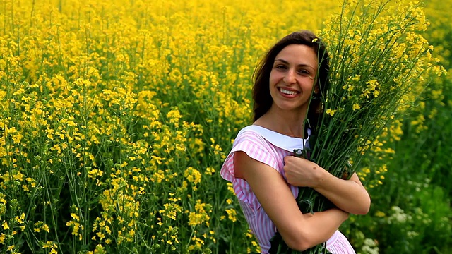 美丽女人放松拿黄花夏季田HD视频素材