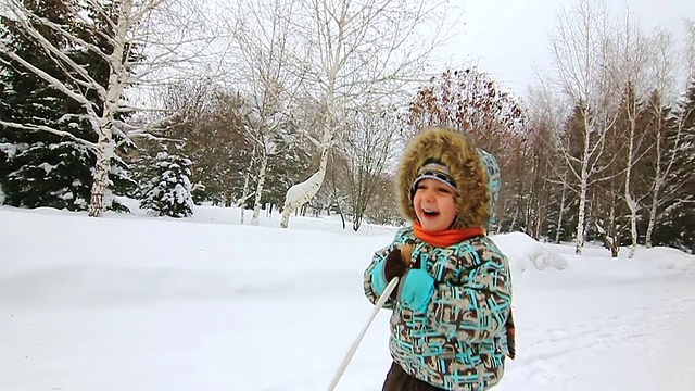 小男孩试着用雪橇撬他妈妈视频素材