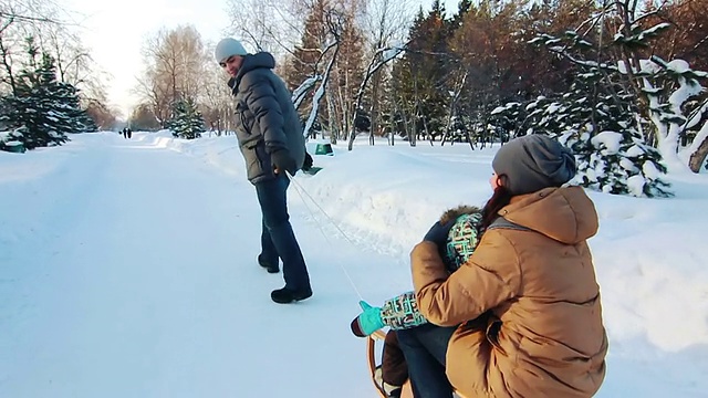 爸爸和妈妈还有儿子拉着雪橇视频素材