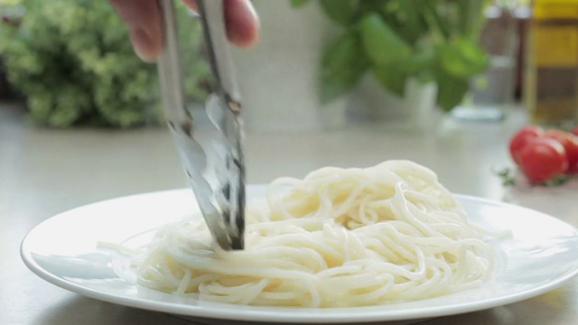 男厨师把意大利面放到盘子里，跟踪镜头视频素材
