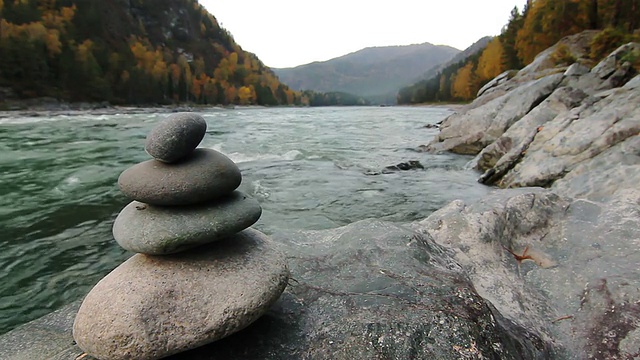 俄罗斯阿勒泰山区河流上的石头金字塔视频素材