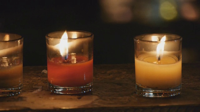 黑暗中三只燃烧的蜡烛。视频素材
