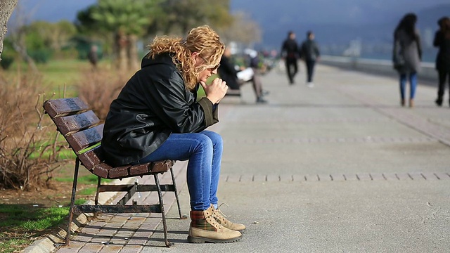 孤独的金发女人坐在银行里视频素材