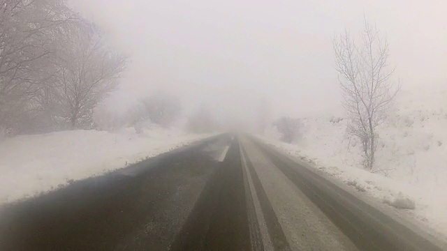 行驶在雪山路上，前车车窗视野视频素材