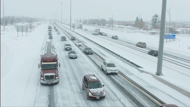 暴风雪中，汽车/卡车在清除积雪的公路上堵塞视频素材