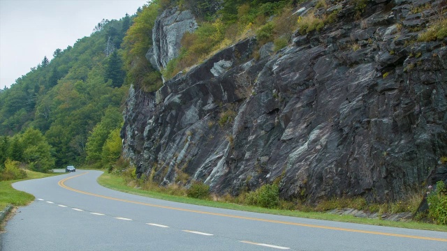 家庭轿车行驶在蓝岭公园路经过石墙视频素材