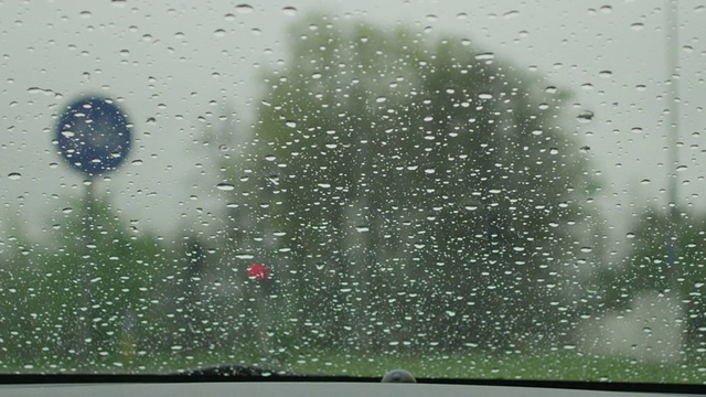 慢动作特写:雨刷在擦拭挡风玻璃上的雨滴视频素材