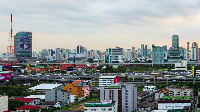 道路或高速公路上繁忙交通的时间推移和商业建筑背景，从白天到晚上视频素材