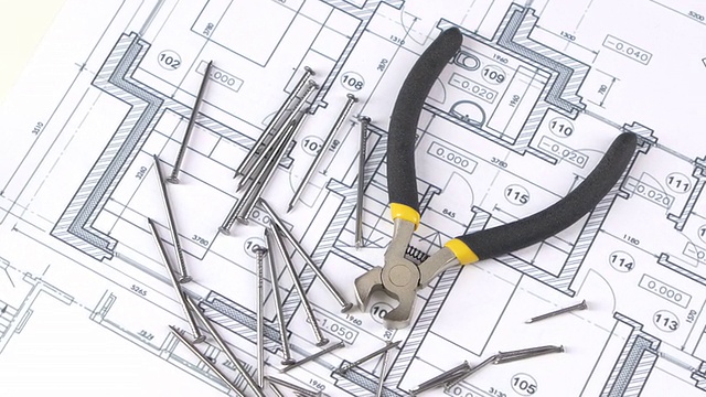 用黄、灰手柄的钢丝切割器切割建筑平面、方案、钉间、旋转视频素材