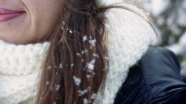 年轻女子戴着白色的帽子和围巾，头发上戴着雪视频素材