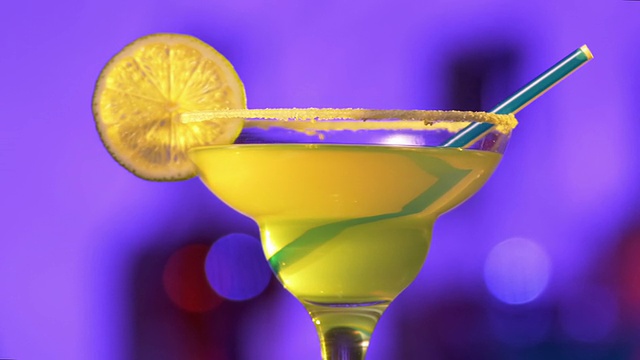绿色和黄色的鸡尾酒，柠檬装饰和椰子边缘，凸轮向上移动视频素材