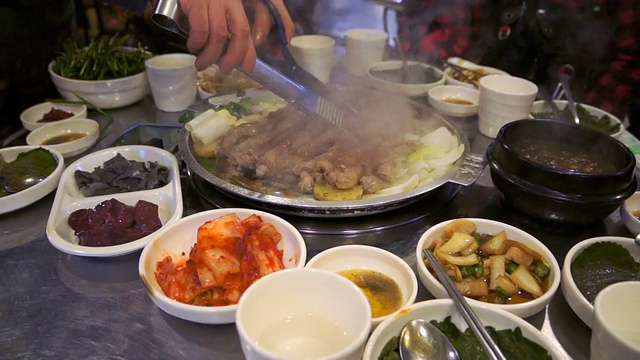 烹饪烧烤猪肠在热板，韩国著名的食物视频素材