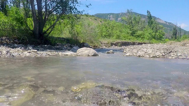 低角度的徒步旅行的女人在徒步穿越山溪溪的轨道视频素材