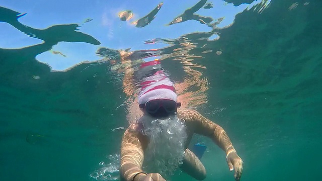 圣诞老人潜水员在热带海滩度假胜地水下浮潜度过圣诞假期视频素材