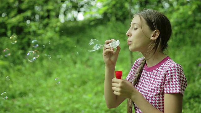 小女孩在室外吹肥皂泡视频素材