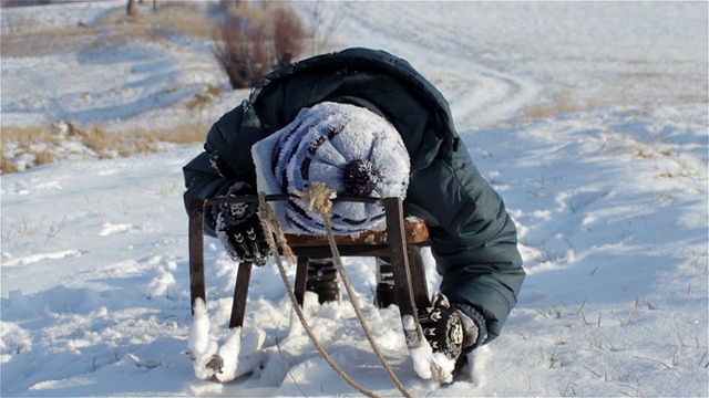 男孩躺在雪橇上视频素材