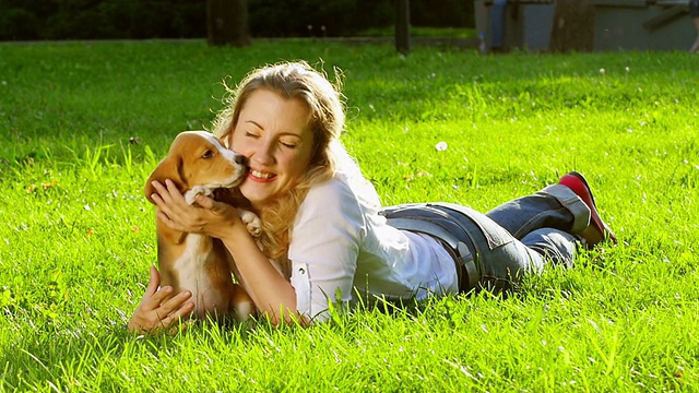 户外肖像快乐的女人与狗小猎犬玩的自然视频素材